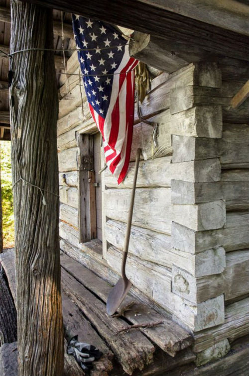 flag hanging off log cabin .jpg